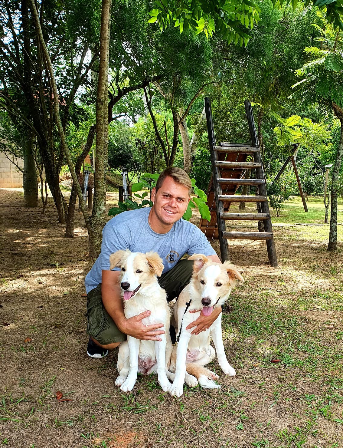 Adestrador com dois filhotes no parque